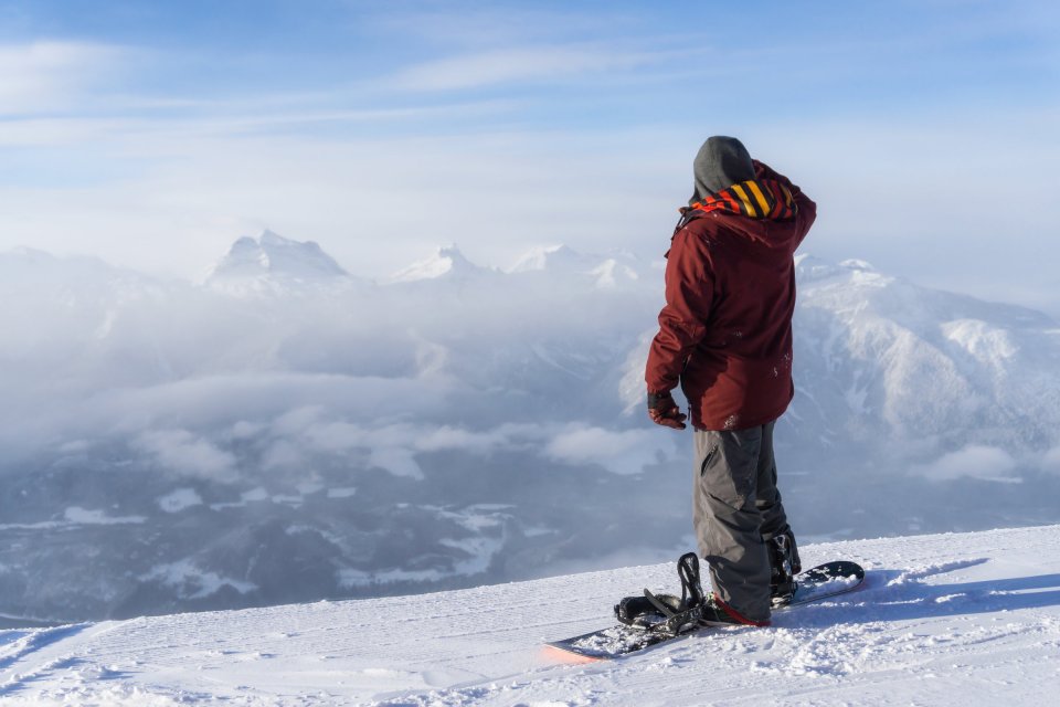 Snowboarder looking at mountains in the distance